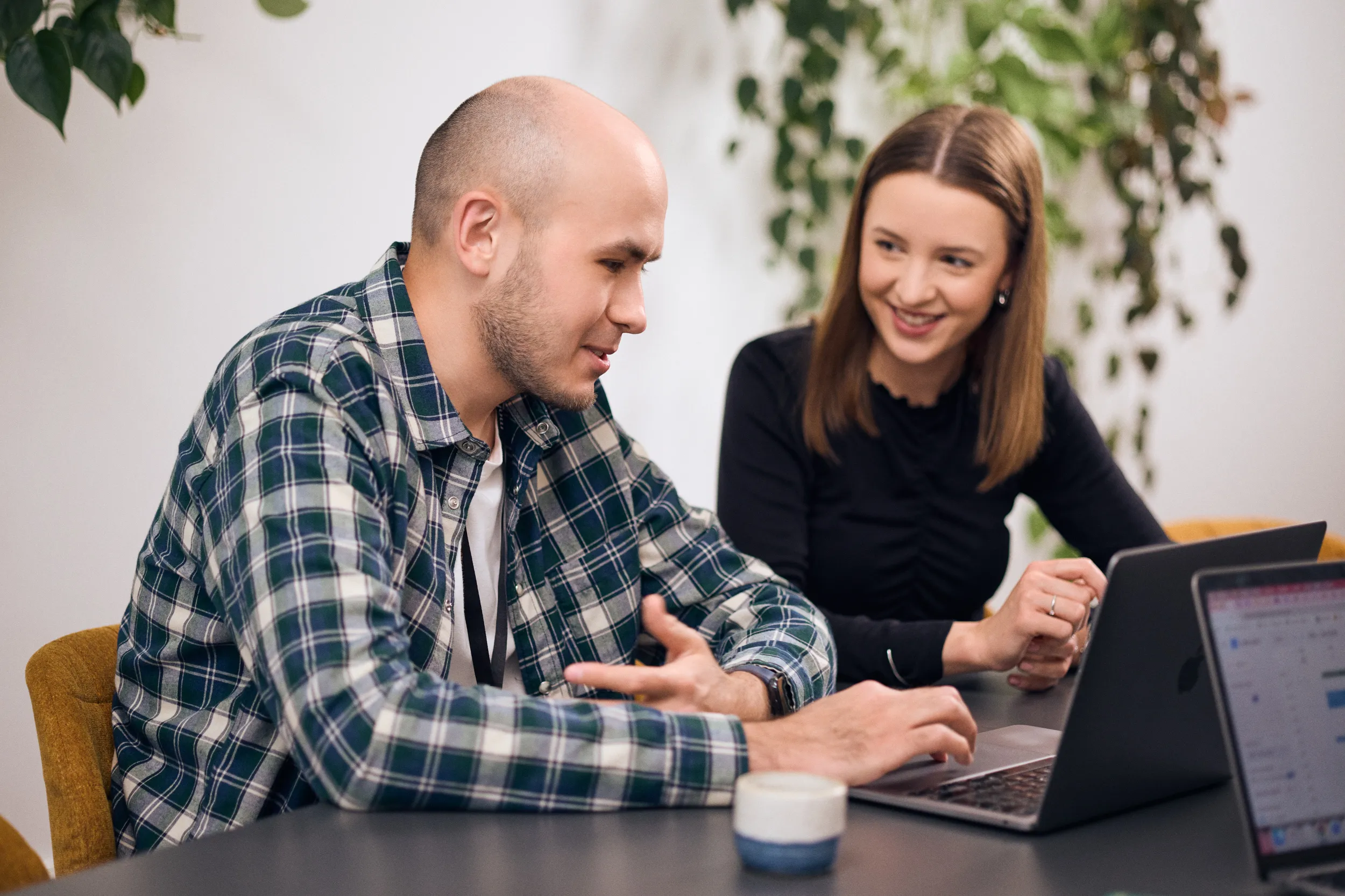 Two mohi.to team members discussing a project over a laptop