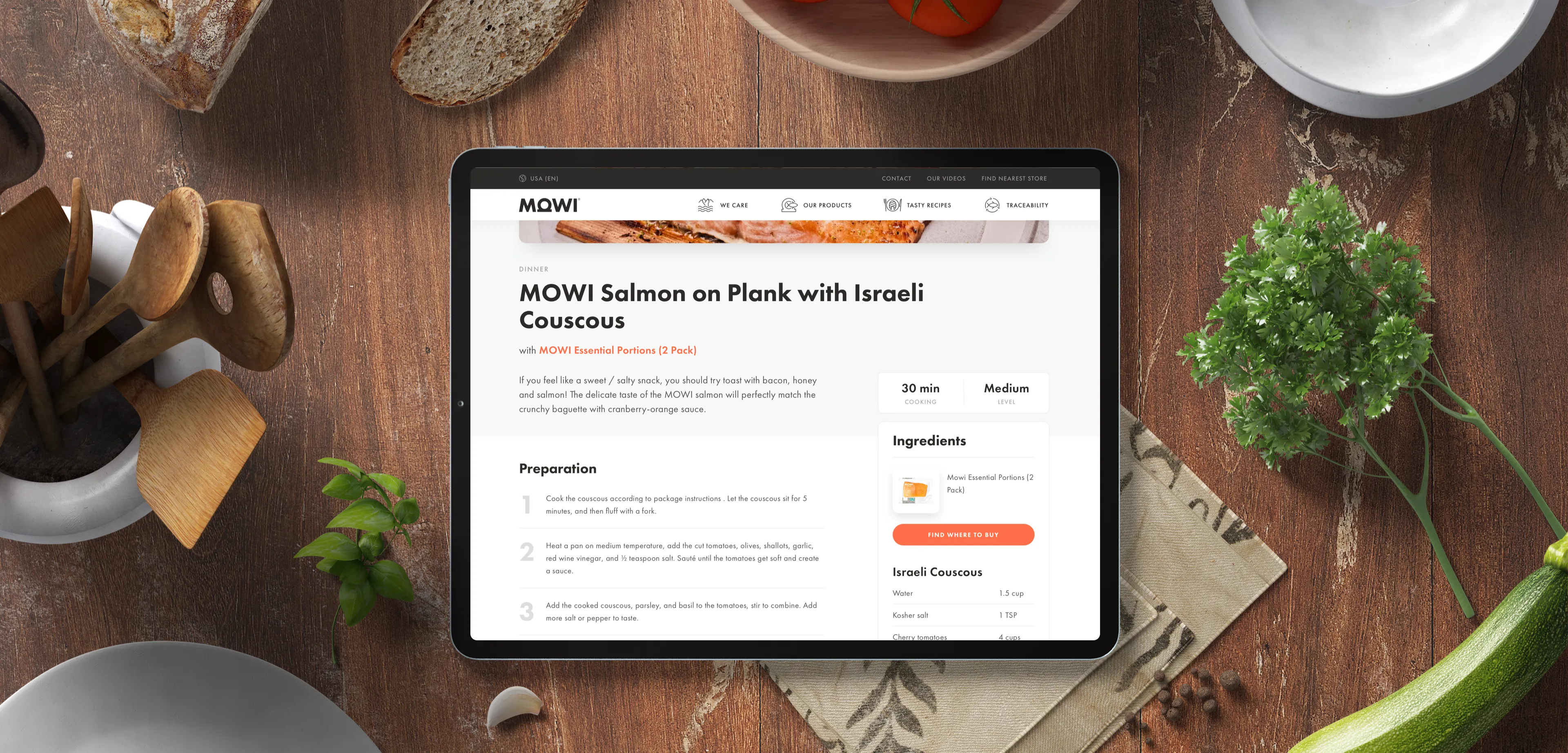 A tablet displaying a Mowi salmon recipe, placed on a kitchen counter among ingredients.