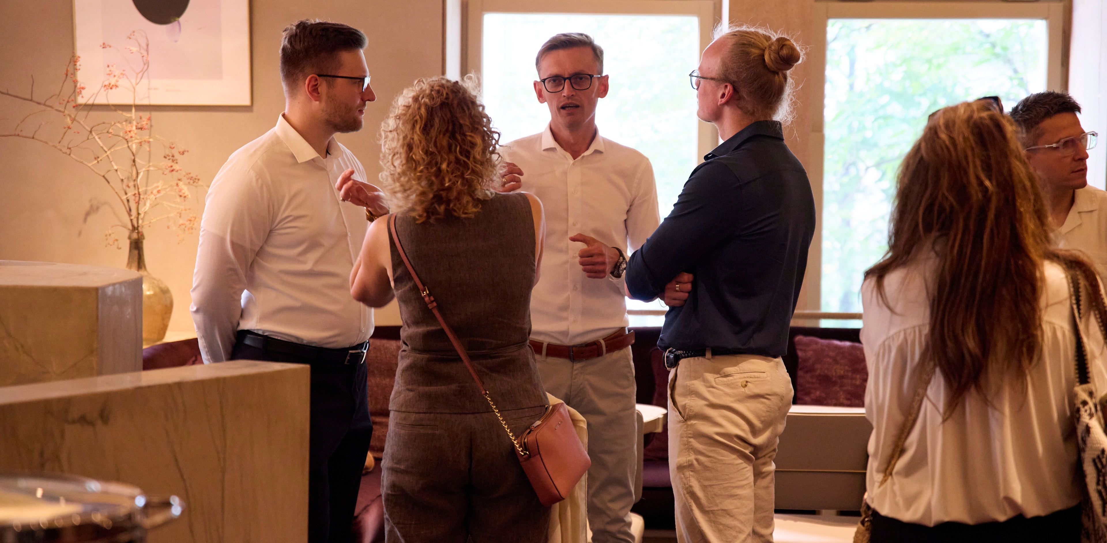 Small group of professionals networking and having a conversation at a business event (Shopify event organized by WeCanFly agency)